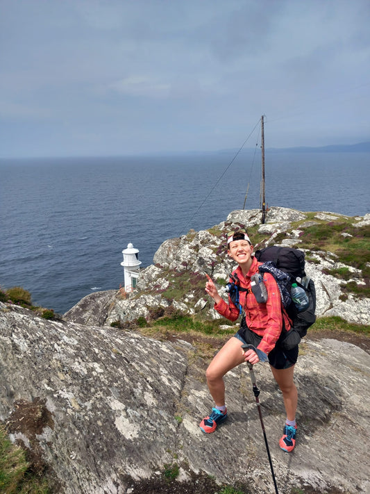 Leika on top of a cliff, looking down on the small lighthouse